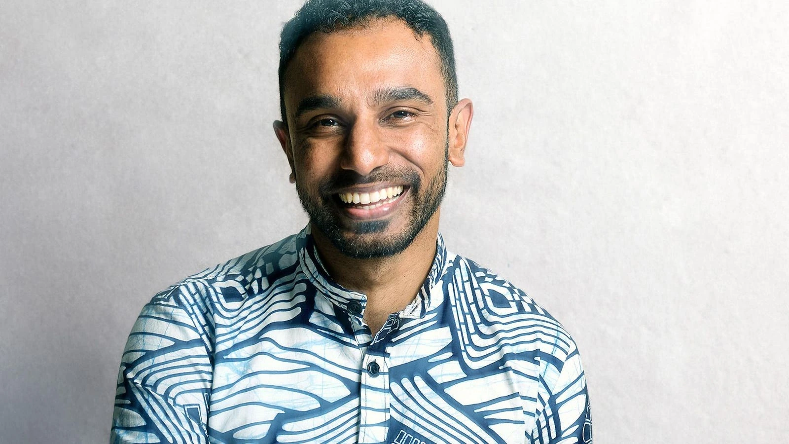 Portrait photo of Benjamin Fernandes smiling against a light background