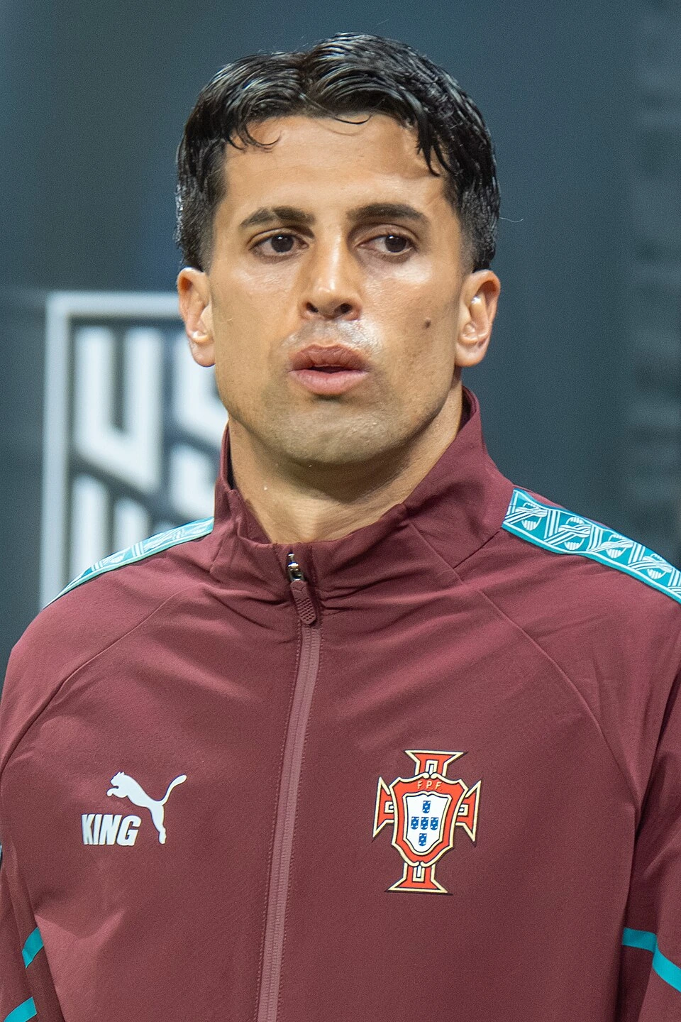 João Cancelo in a Portugal team tracksuit during a match-day setting, close-up portrait photo