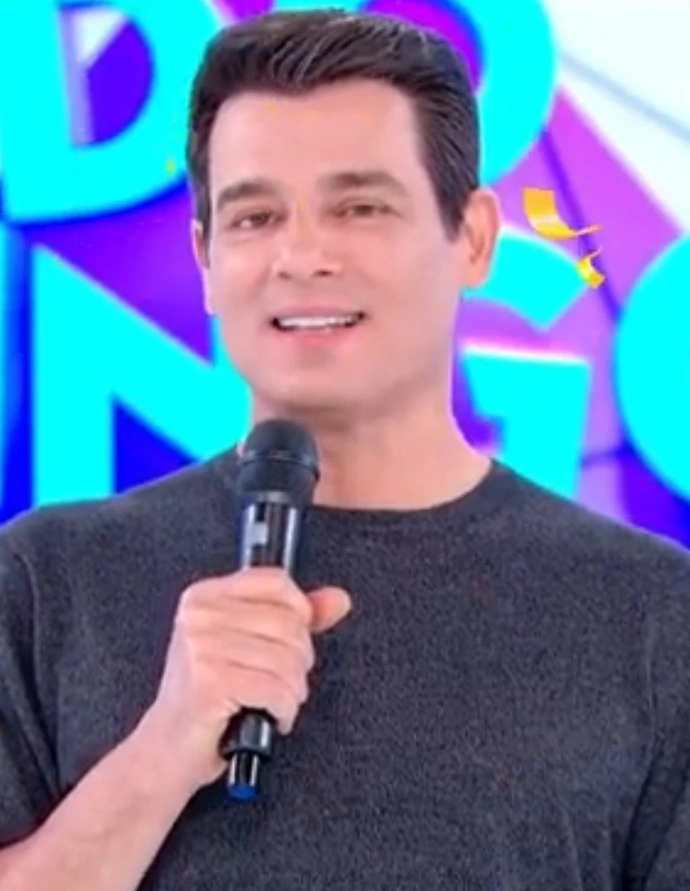 Celso Portiolli holding a microphone on television set